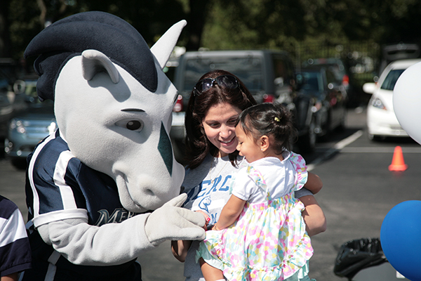 Mav Mascot with Mercy student and young child